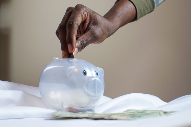 A property owner putting a money for fees into a piggy bank.