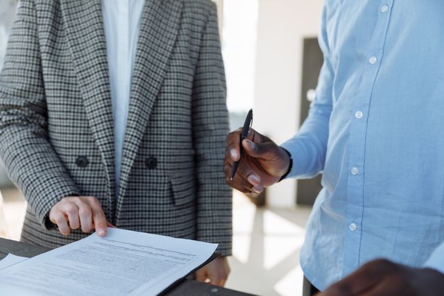 A Richmond property owner standing with a manager and preparing to sign a document on a clipboard.